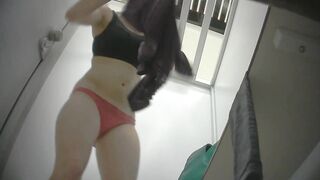 Spycam in women's bathroom shows beautiful woman changing clothes.